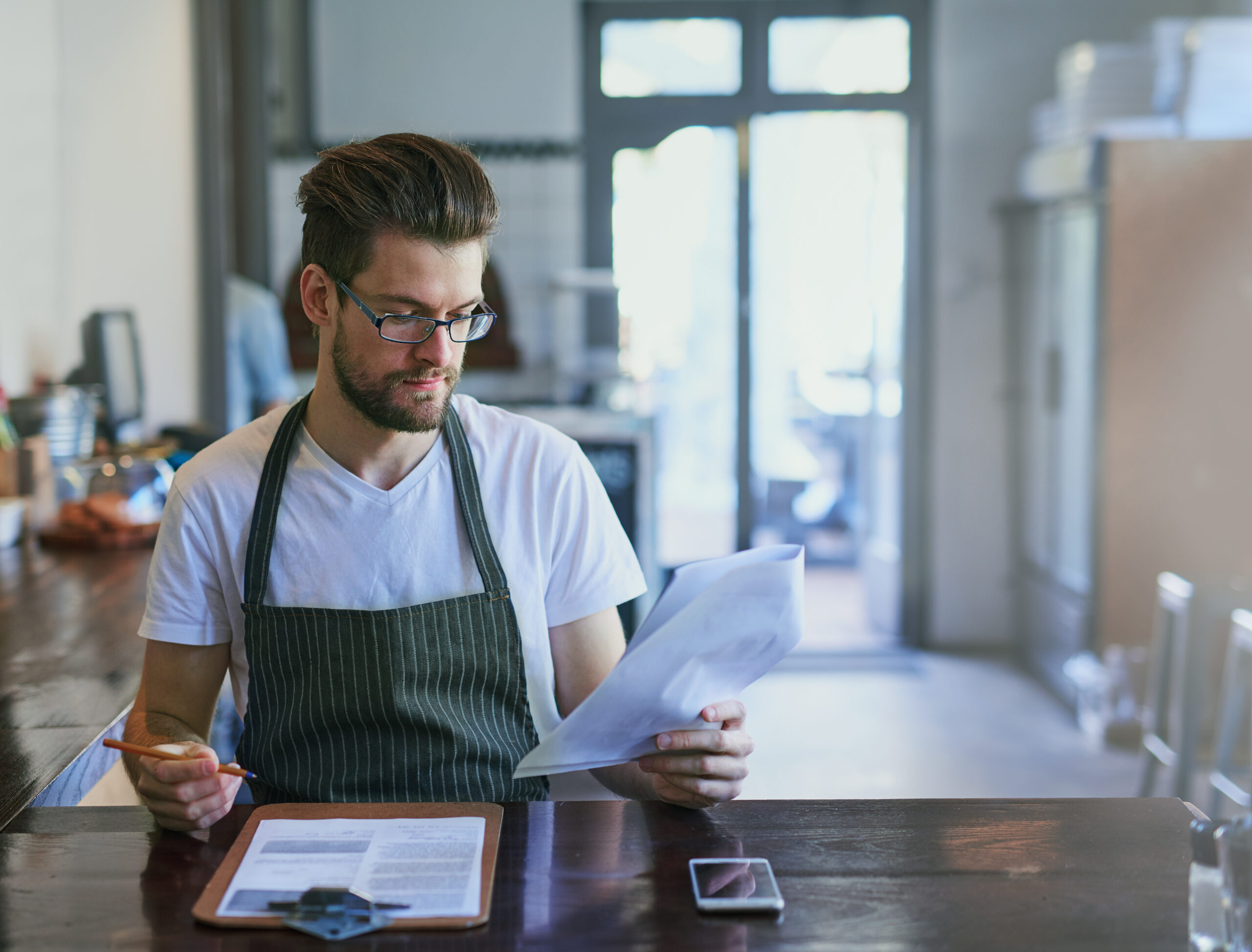 A restaurant manager analyzing labor costs and menu profitability in a commercial kitchen setting. A restaurant manager analyzing labor costs and menu profitability in a commercial kitchen setting.
